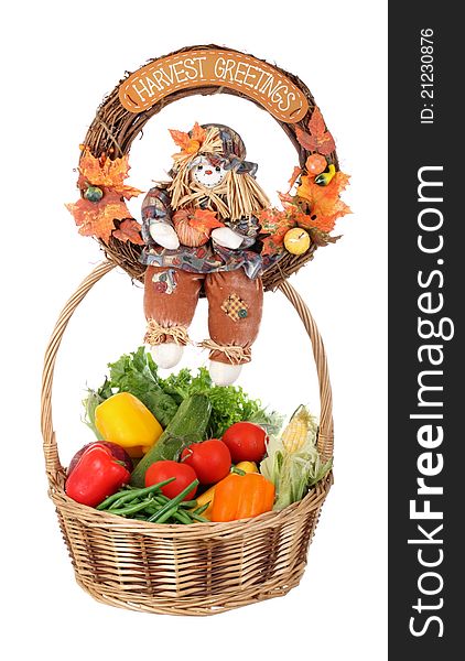 Harvest wreath sitting on top of a basket of vegetables isolated on white. Harvest wreath sitting on top of a basket of vegetables isolated on white