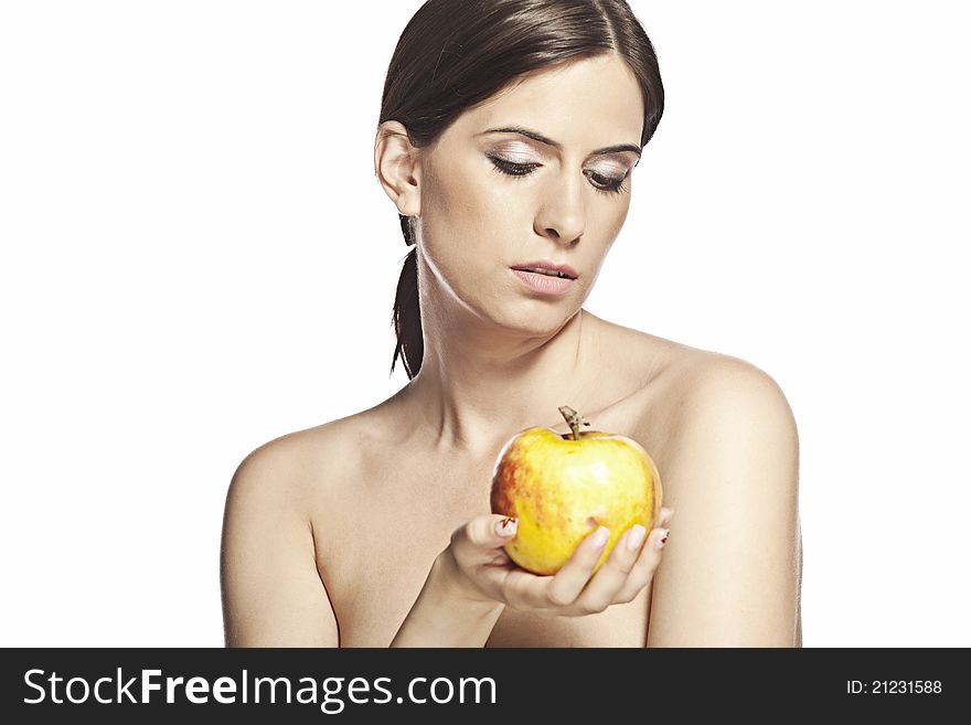 Beautiful woman is looking down at a big yellow and red apple. She is naked and has her hair in a ponytail. Beautiful woman is looking down at a big yellow and red apple. She is naked and has her hair in a ponytail.