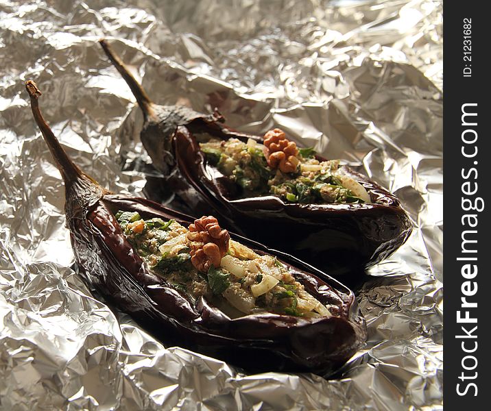 Baked aubergines stuffed with walnut filling on foil