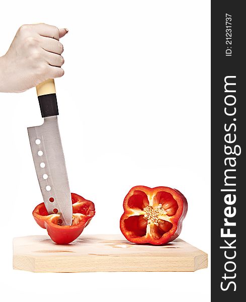 Woman cutting a perfect red pepper on a wood cutting board with a sharp kitchen knife. Woman cutting a perfect red pepper on a wood cutting board with a sharp kitchen knife.