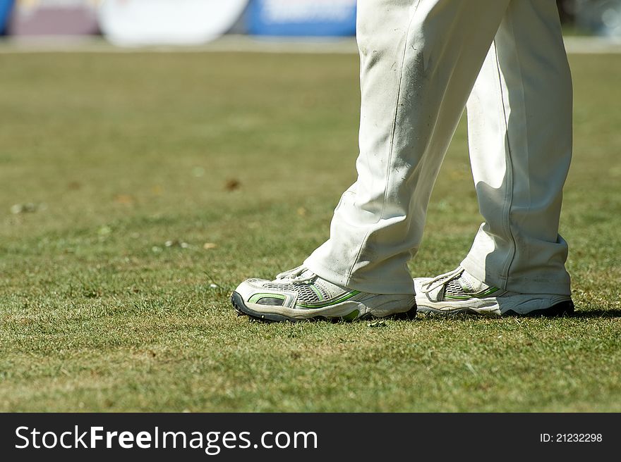Feet of a cricketer in traditional white trousers