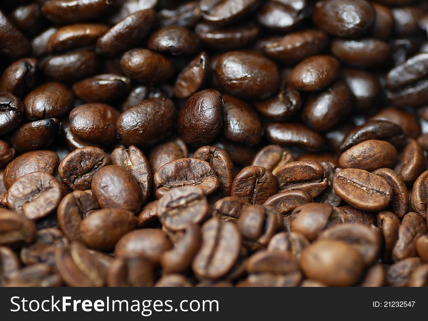 Decaffinated and caffinated coffee beans piled next to each other. Decaffinated and caffinated coffee beans piled next to each other.