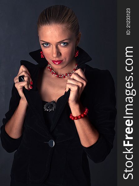 Girl with a stern look, dressed in black with red accessories in the form of a vampire. Girl with a stern look, dressed in black with red accessories in the form of a vampire