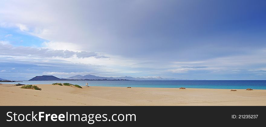 Panoramo of the desert at Fuerteventura near the city of Corralejo, see on the Island of Ls Lobos with amazing sky and colors. Panoramo of the desert at Fuerteventura near the city of Corralejo, see on the Island of Ls Lobos with amazing sky and colors