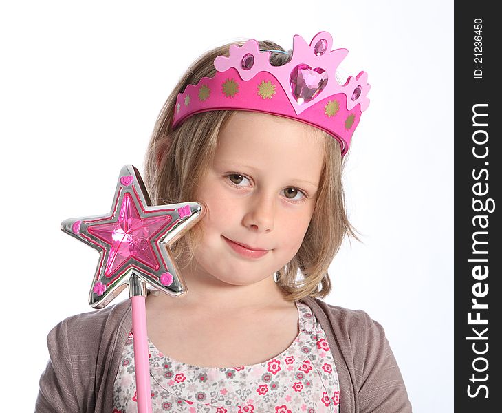 Fair princess fancy dress time for young primary school age girl wearing pink crown on her head and holding a pink magic wand star. She has blonde hair. Fair princess fancy dress time for young primary school age girl wearing pink crown on her head and holding a pink magic wand star. She has blonde hair.