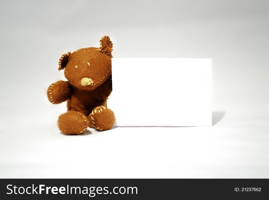 Brown teddy holding white card in white background. Brown teddy holding white card in white background