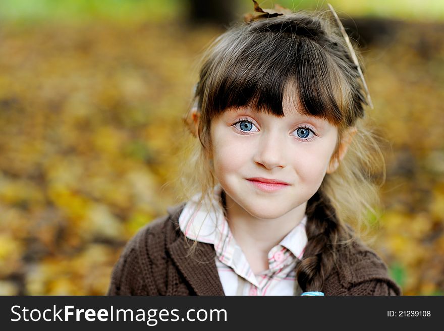 Portrait of adorable child girl with blue eyes in autumn forest. Portrait of adorable child girl with blue eyes in autumn forest