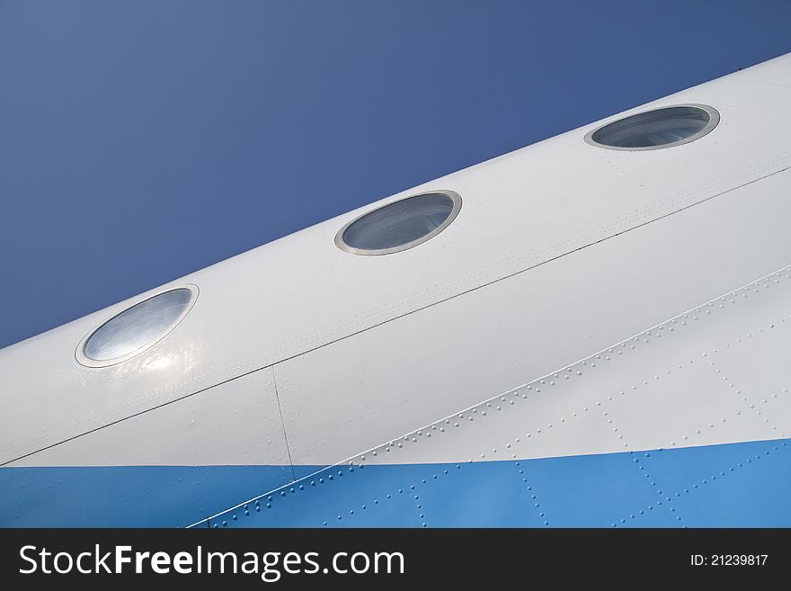 Air plane fuselage with tree illuminators on blue sky background. Air plane fuselage with tree illuminators on blue sky background