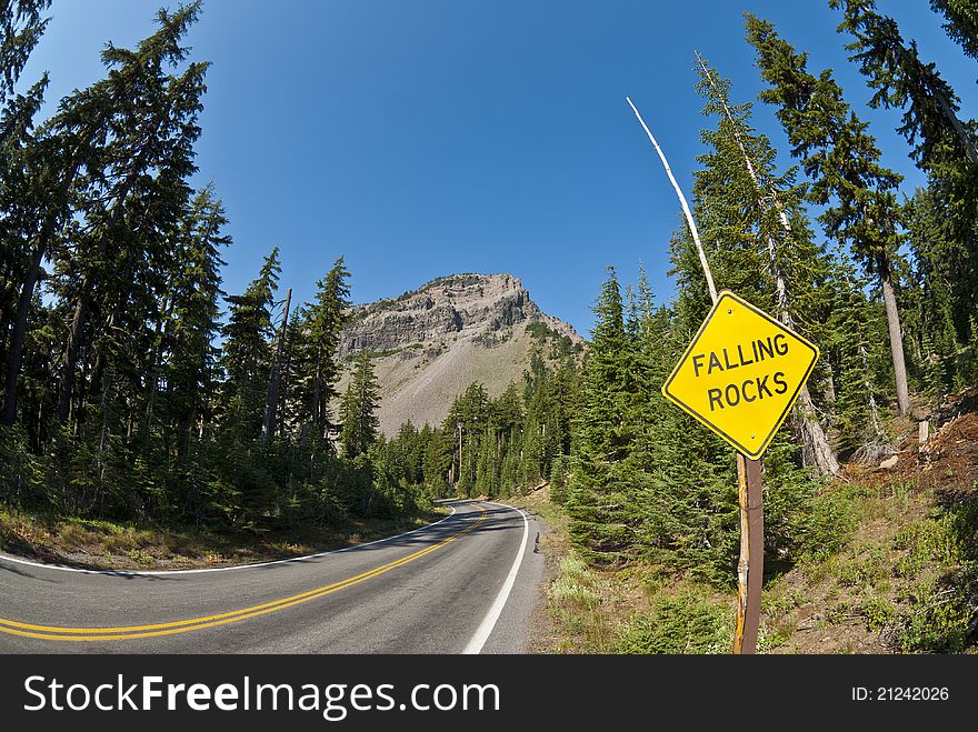 A yellow diamond sign warning for falling rocks near Crater Lake. A yellow diamond sign warning for falling rocks near Crater Lake.