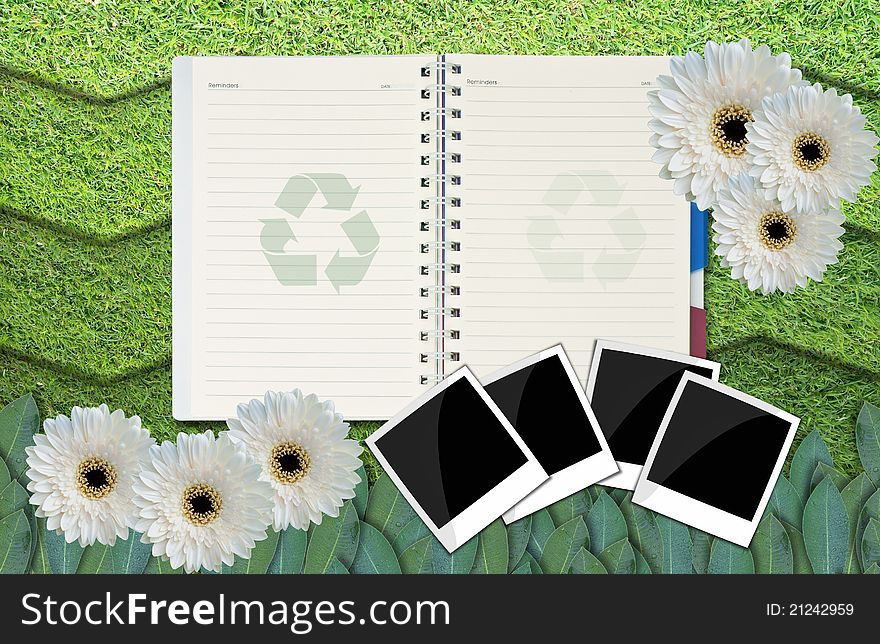 Opened blank notepad on grass background.