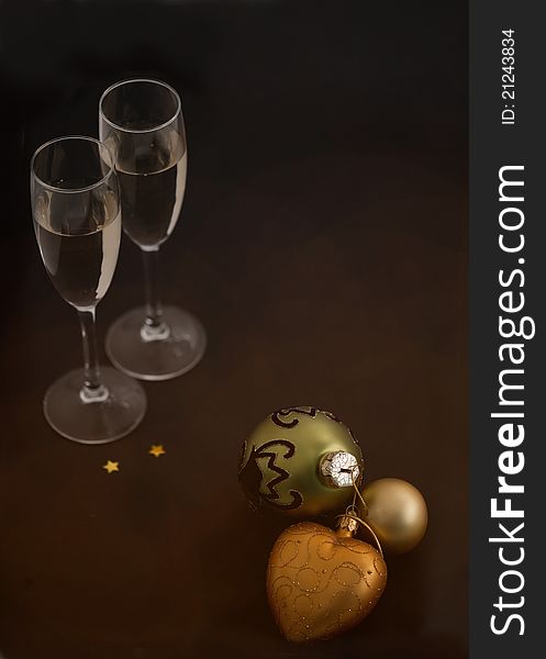 Christmas balls and glasses of champagne on black background