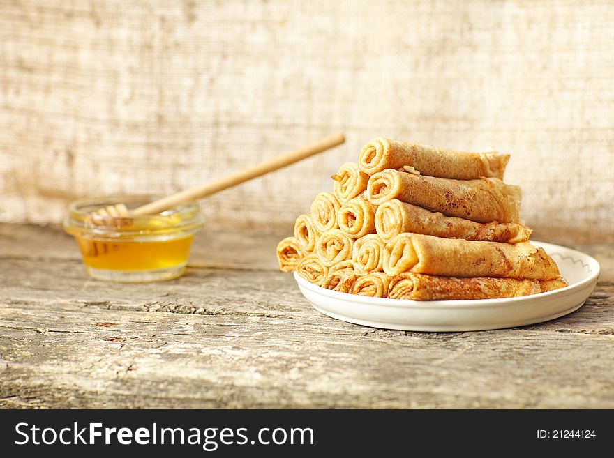 Fritters (pancakes) with honey against a wooden structure