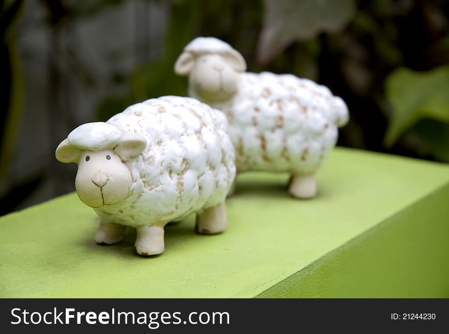 Cute sheep ceramic doll on green floor. Cute sheep ceramic doll on green floor