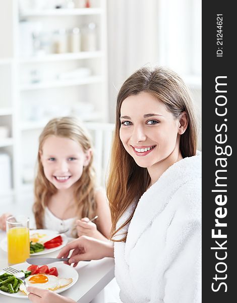 A mother and child have breakfast in the kitchen. A mother and child have breakfast in the kitchen