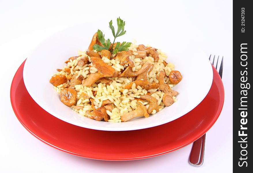 Risotto with mushrooms on a plate decorated with parsley and a fork