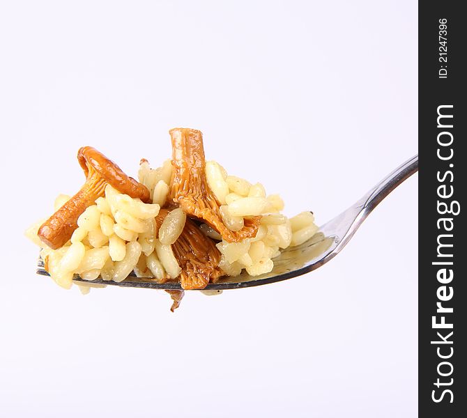 Risotto with mushrooms on a fork on white background