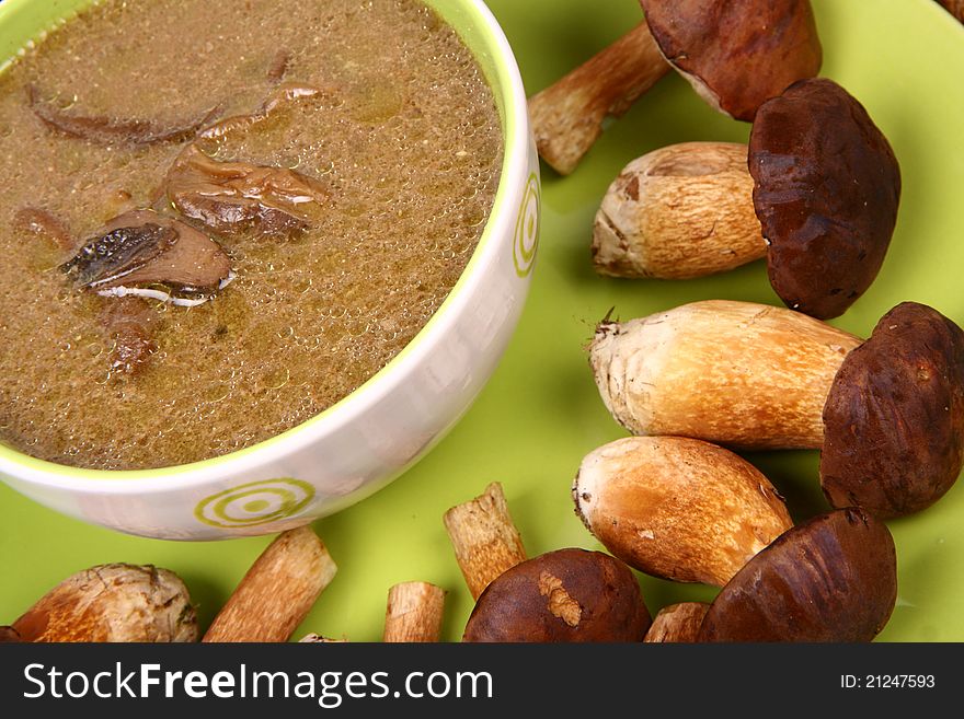 Mushroom soup in a bowl with some mushrooms around it and some pinecones