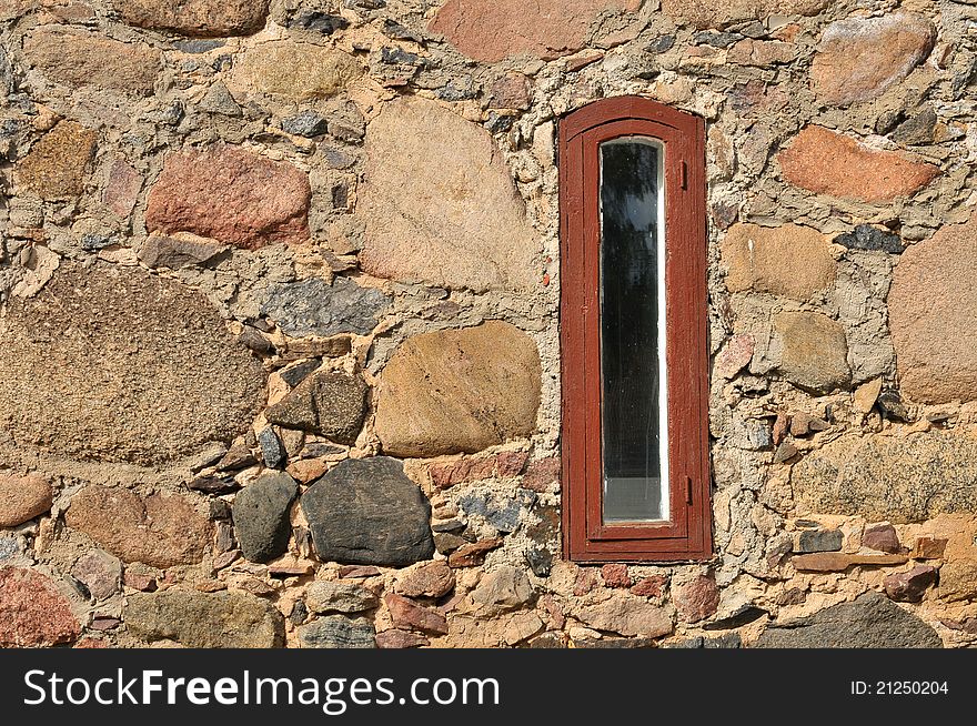 Narrow, red window in stone wall. Narrow, red window in stone wall