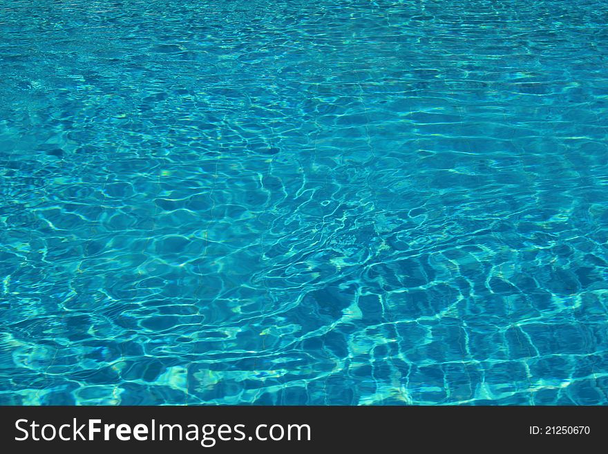 Abstract patterns created by ripples and light on the blue water of a swimming pool. Abstract patterns created by ripples and light on the blue water of a swimming pool