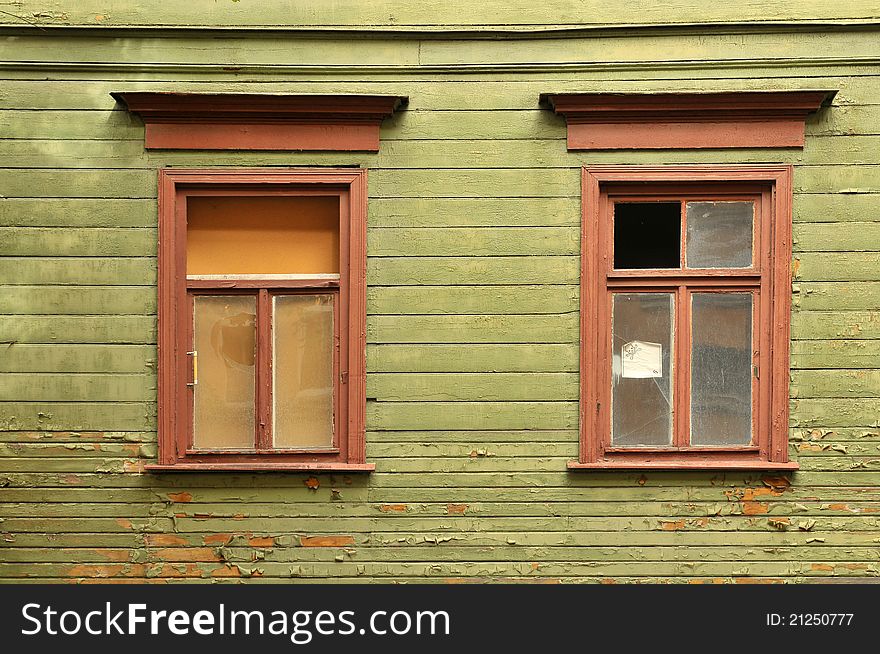 Old broken window on a green wooden wall