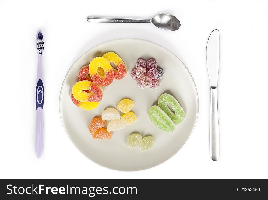 A toothbrush used as cutlery and sweets on a plate. A toothbrush used as cutlery and sweets on a plate