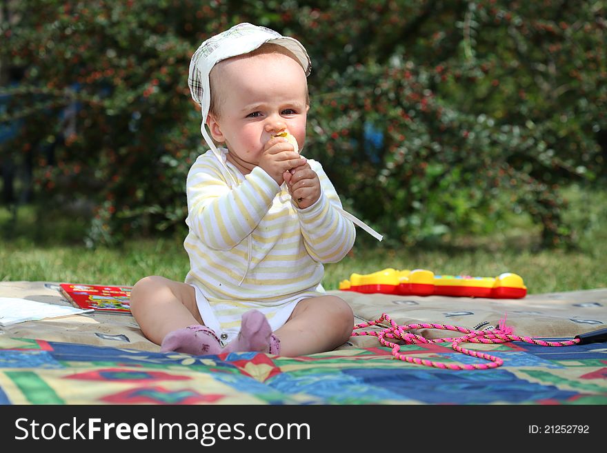 Smiling boy on the meadow eating pear