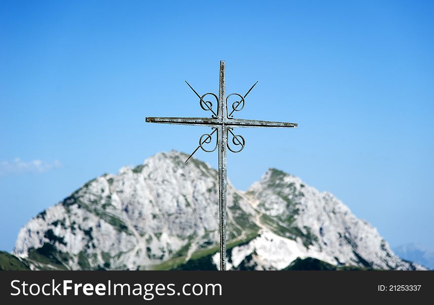 Cross of iron in front of blue sky and mighty hills. Cross of iron in front of blue sky and mighty hills