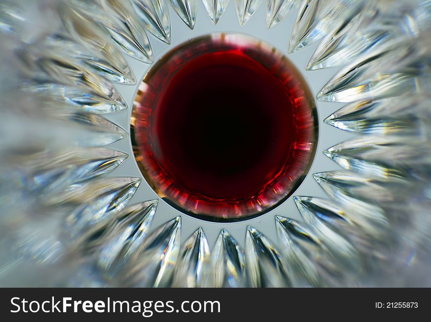 Splash of red wine at the bottom of the crystal glass.