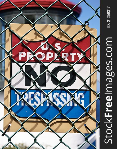 U.S. Property NO TRESPASSING sign posted on chain link fence in front of Makapu'u Lighthouse on Oahu, Hawaii.