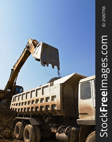 Excavator loader and truck during Earth moving works outdoors  at the quarry