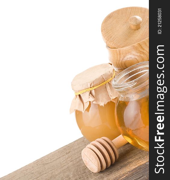 Jar full of honey and stick on white background