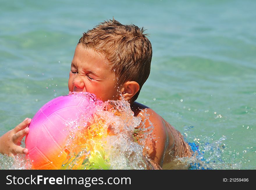 Boy in the water playing with a ball in the sea
