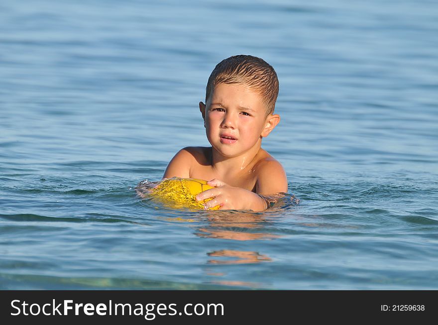 Boy in the water playing with a ball