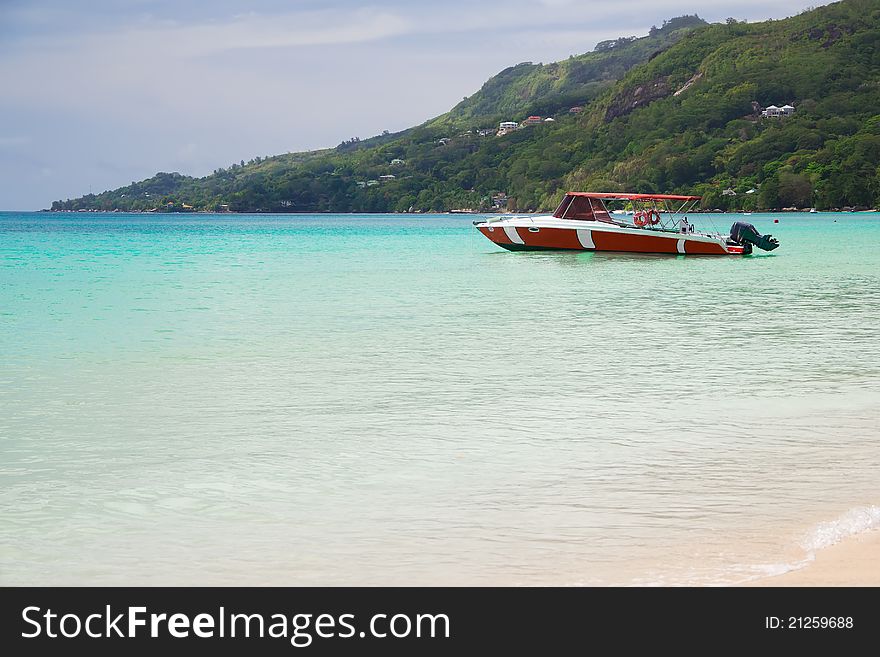 Seascape with a red fisherman's boat and a hill as background. Seascape with a red fisherman's boat and a hill as background