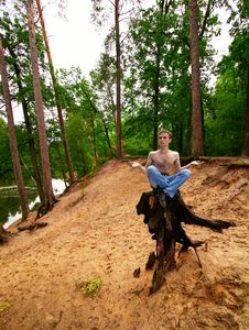 Young Guy Meditates, Sitting On A Stub Stock Image