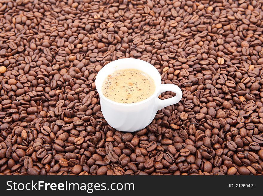 Cup of fresh coffee against coffee grains