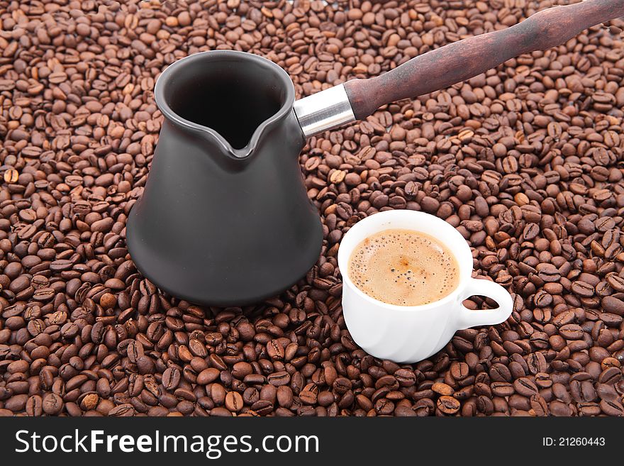 Cup of fresh coffee against coffee grains. Cup of fresh coffee against coffee grains