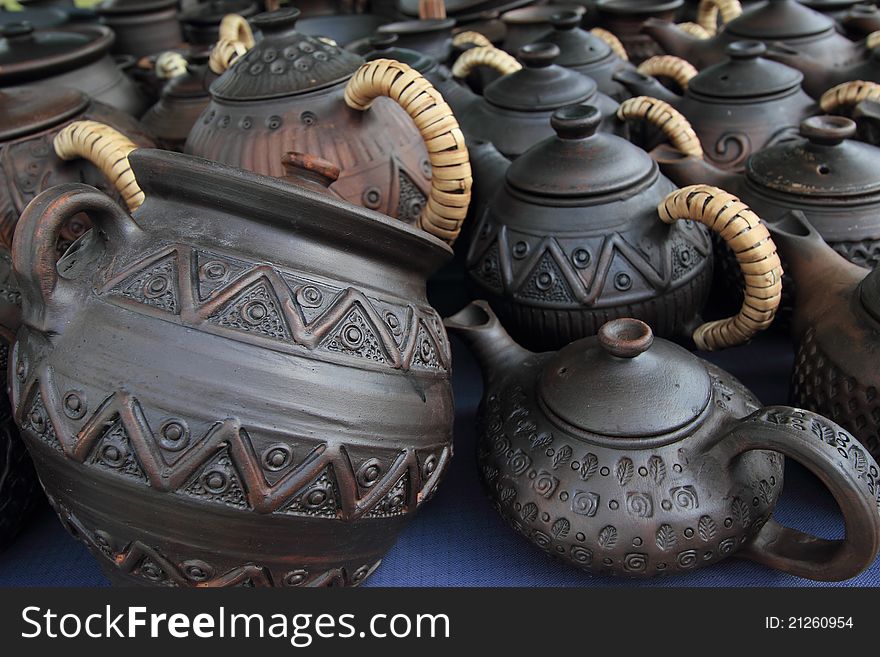 Pottery: photo is a lot of pots, mugs and the cups located on one surface,. Pottery: photo is a lot of pots, mugs and the cups located on one surface,
