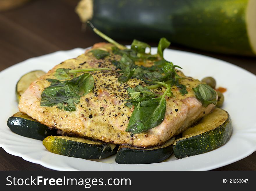 Tasty salmon filet on a white plate, with grilled vegetables. Tasty salmon filet on a white plate, with grilled vegetables