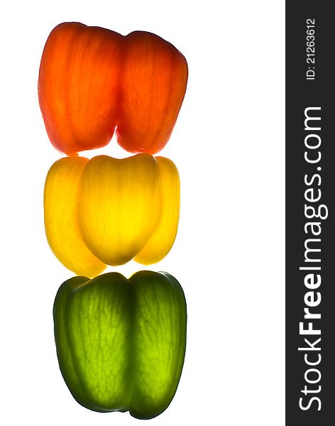 Paprika red, yellow, green on a white background illuminated from the bottom point located vertically. Paprika red, yellow, green on a white background illuminated from the bottom point located vertically