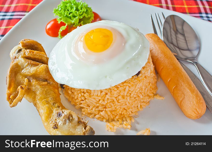 American fried rice with fried chicken ,egg and sausage on table. American fried rice with fried chicken ,egg and sausage on table