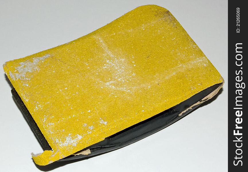 Yellow sandpaper and block on a white background. Yellow sandpaper and block on a white background