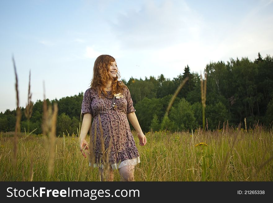 Beautiful pregnant girl on the field