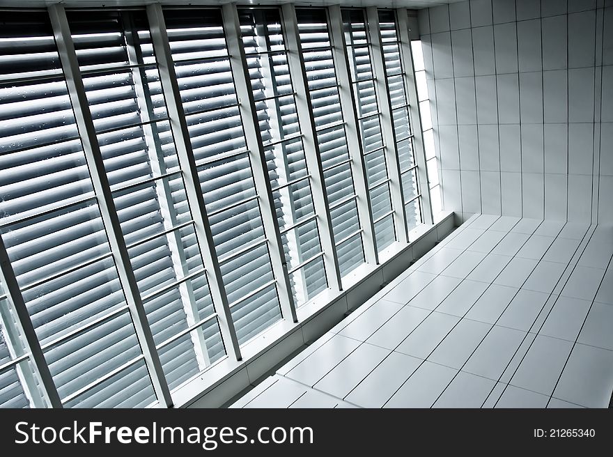 Contrast window panels with blinds beside tiled pathway