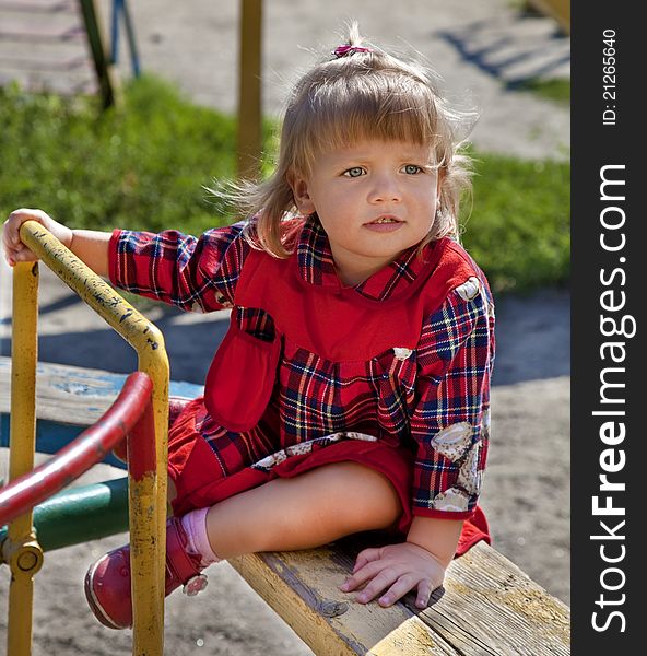 Adorable little girl having fun on a swing in summer