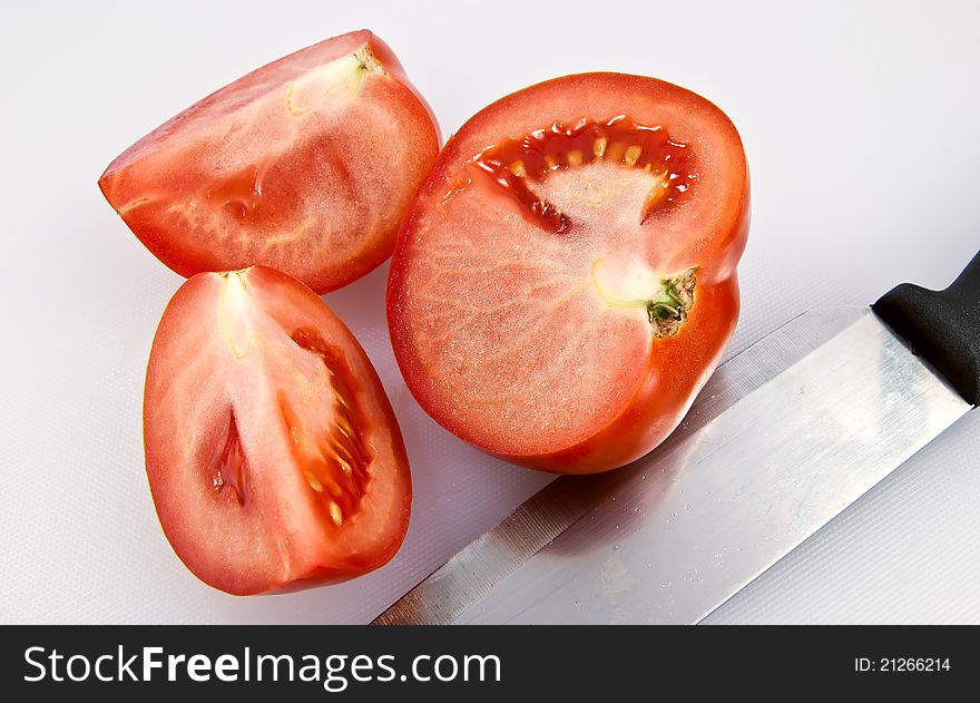 Red tomatoes on hardboard with a knife. Red tomatoes on hardboard with a knife.