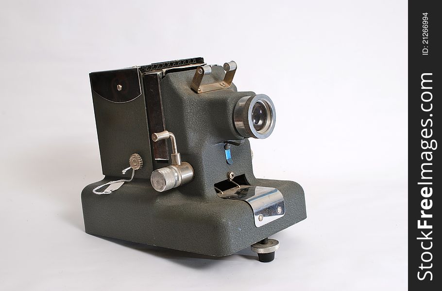 An Antique slide projector made of grey metal on an easily removable light grey background.