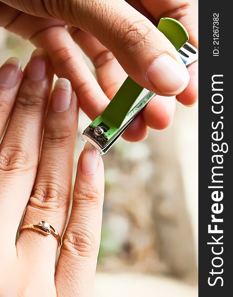 Girl cutting her nail by left hand. Girl cutting her nail by left hand