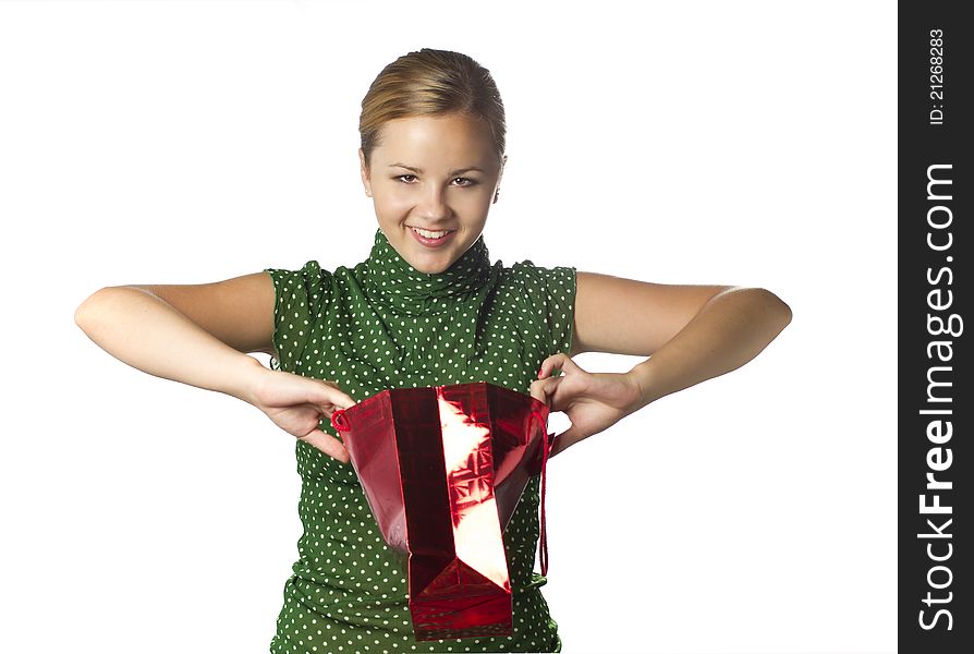 Surprised young girl is opening gift bag and crafty smiling isolated over white. Surprised young girl is opening gift bag and crafty smiling isolated over white