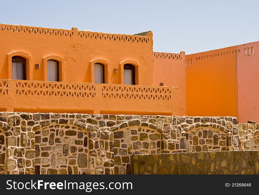 Nice orange hotel in Egypt with clear sky and wall. Summer vacation concept.